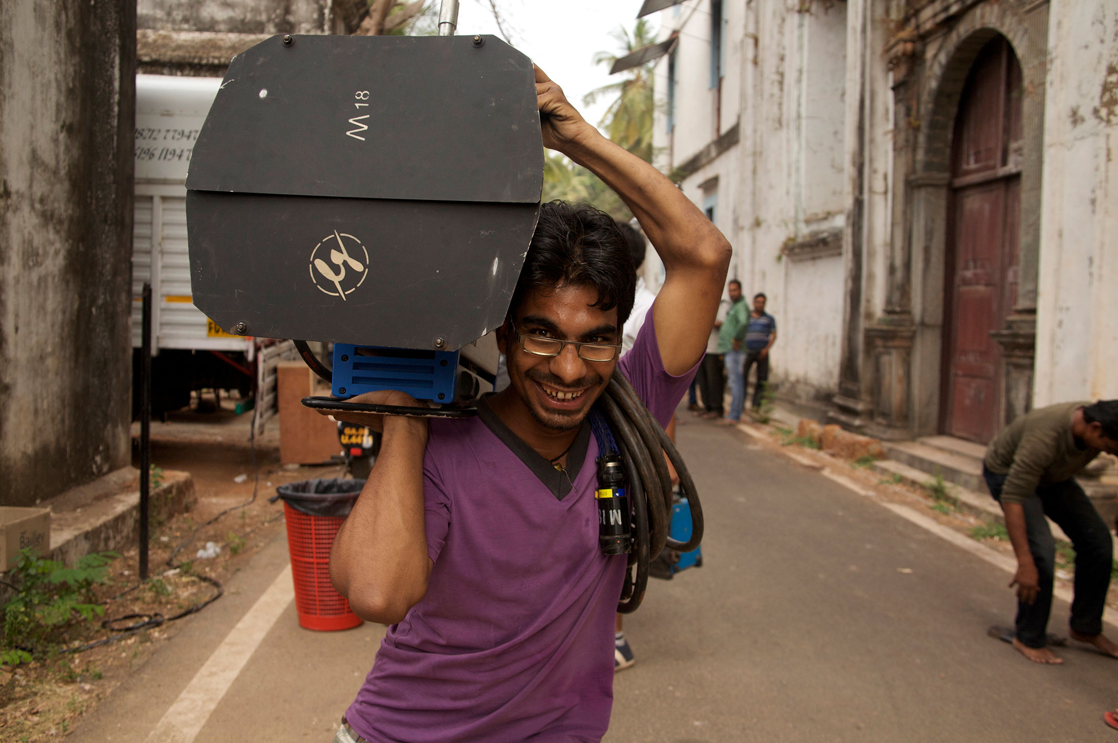 Film Crew in India: A lightboy carrying a light on an Indian location shoot